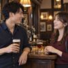 パブでドリンクを手に会話する成人の男女（イメージ）
