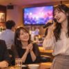 共用フロアのカラオケバーで歌と交流を楽しむ大人たち