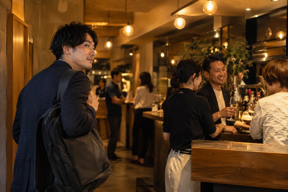 パブリックスタンドのようなバーに一人で入店する大人の男性のイメージ