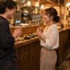 立ち飲み屋のカウンターで会話を楽しむ成人の男女